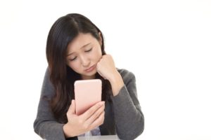 下向きて゛スマホを見る女性